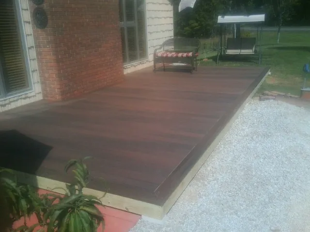 Freshly stained wood deck built against a brick home in Nashville