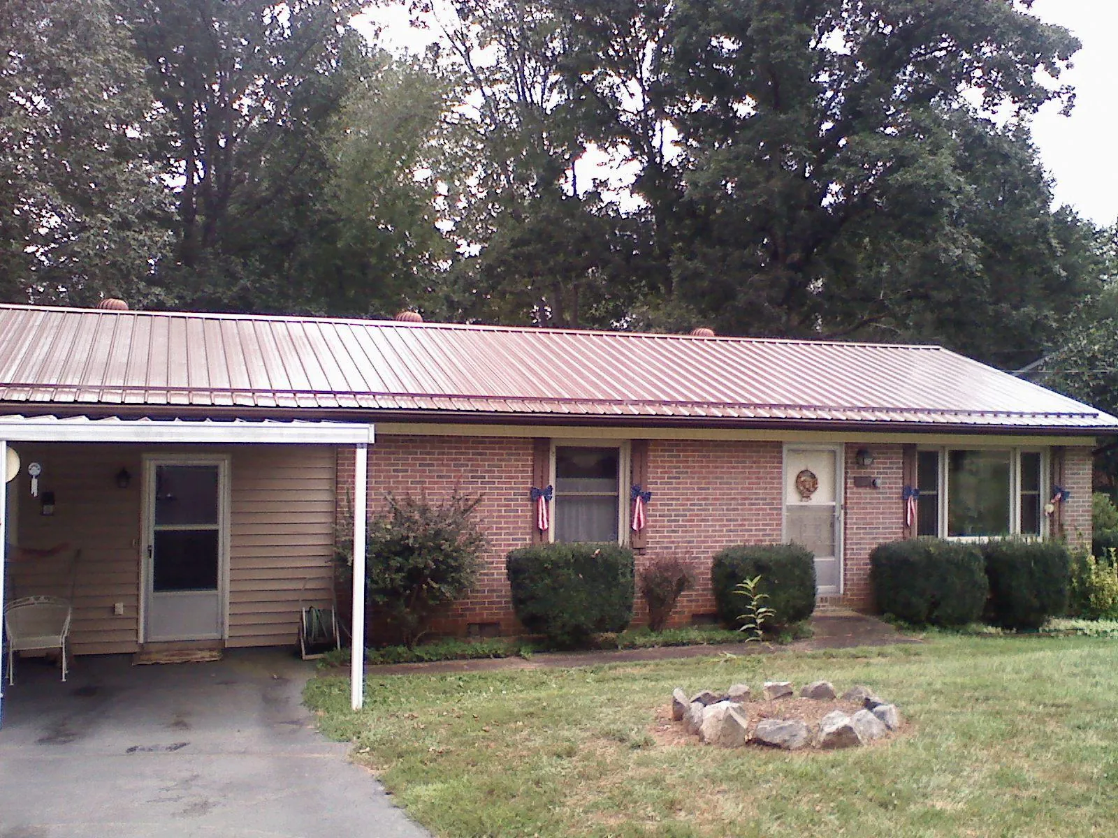 Bronze metal roof and carport on a brick ranch home — Roof Repair work by our crew in Nashville